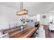 Well-lit dining area with a large table and chairs adjacent to a modern white kitchen at 4308 Fly Rod Ter, Parrish, FL 34219