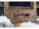 Close-up of a stone fireplace with a modern linear firebox filled with decorative stones at 4308 Fly Rod Ter, Parrish, FL 34219