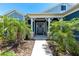 A welcoming front porch with decorative columns, palm trees, and a charming wreath on the front door at 4308 Fly Rod Ter, Parrish, FL 34219