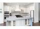 Bright kitchen with white cabinets, marble counters, and a large island with bar seating at 4308 Fly Rod Ter, Parrish, FL 34219
