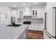 Modern kitchen features white cabinets, stainless steel appliances, and a large island with marble countertop at 4308 Fly Rod Ter, Parrish, FL 34219