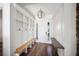 Bright mudroom with built-in storage bench, coat hooks, wood floors and natural light at 4308 Fly Rod Ter, Parrish, FL 34219
