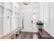 Bright mudroom with built-in storage bench, coat hooks, wood floors and console table at 4308 Fly Rod Ter, Parrish, FL 34219