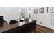 A home office featuring a large desk and wood flooring and two sunny windows with white trim at 4308 Fly Rod Ter, Parrish, FL 34219