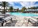 Resort-style pool with lounge chairs, swaying palms, and clear blue water offers a relaxing getaway at 4308 Fly Rod Ter, Parrish, FL 34219