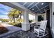 Relaxing front porch setting with a white rocking chair and swing offers a peaceful retreat at 4308 Fly Rod Ter, Parrish, FL 34219