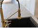 A close-up of a modern gold kitchen faucet over a sink at 4308 Fly Rod Ter, Parrish, FL 34219