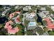 Aerial view of a residential area featuring red-tiled roofs, waterways, community pools, and tennis courts amidst lush greenery at 4325 46Th W Ave # 202, Bradenton, FL 34210
