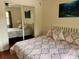 Bedroom featuring a mirrored closet door, a large window, curtains, and a patterned bedspread at 4325 46Th W Ave # 202, Bradenton, FL 34210