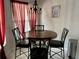 Close up of a round dining table with a decorative chandelier and red curtains at 4325 46Th W Ave # 202, Bradenton, FL 34210