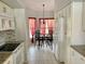 Cozy kitchen with white cabinetry and a dining area featuring red curtain accents at 4325 46Th W Ave # 202, Bradenton, FL 34210