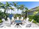 Cozy fire pit area with comfortable seating, perfect for gatherings under the stars amidst palm trees at 4625 Foxtail Dr, Parrish, FL 34219