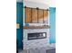 Outdoor fireplace with gray tile, wooden mantle and decorative cabinets with sliding doors at 4625 Foxtail Dr, Parrish, FL 34219