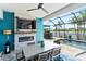 Covered outdoor patio with fireplace, tv, and pool overlooking water at 4625 Foxtail Dr, Parrish, FL 34219