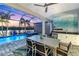 Beautiful outdoor patio space includes a dining area, pool, and lake views at sunset at 4625 Foxtail Dr, Parrish, FL 34219