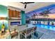 Inviting patio area with outdoor dining, fireplace, and pool overlooking the lake at 4625 Foxtail Dr, Parrish, FL 34219