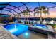 Beautiful pool at night, with lighting, spa, lake views, and outdoor dining areas at 4625 Foxtail Dr, Parrish, FL 34219