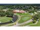 Aerial view of golf course and clubhouse with landscaped grounds, fountain, and ample parking at 5630 Golf Pointe Dr # 108, Sarasota, FL 34243