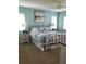Primary bedroom featuring a decorative bed frame, plush bedding, and large picture window at 5630 Golf Pointe Dr # 108, Sarasota, FL 34243