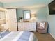 Well-lit bedroom with a dresser, mirror, chair, and TV creating a comfortable space at 5630 Golf Pointe Dr # 108, Sarasota, FL 34243