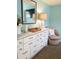 Bedroom showcasing a white dresser with decor, a mirror, a cozy chair, and a television at 5630 Golf Pointe Dr # 108, Sarasota, FL 34243