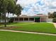 Well-maintained clubhouse with tile roof is surrounded by green lawns and beautiful landscaping at 5630 Golf Pointe Dr # 108, Sarasota, FL 34243