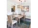 Bright dining room with a rustic table, chairs, modern chandelier and colorful art at 5630 Golf Pointe Dr # 108, Sarasota, FL 34243