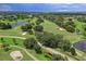 Scenic aerial view highlighting a meticulously maintained golf course with ponds and mature trees at 5630 Golf Pointe Dr # 108, Sarasota, FL 34243