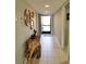 Entrance hallway with a unique wooden console table, decorative mirrors, and tiled flooring at 5630 Golf Pointe Dr # 108, Sarasota, FL 34243