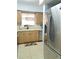 Bright kitchen features light wood cabinets, neutral countertops, stainless steel appliances, and modern lighting fixture at 5630 Golf Pointe Dr # 108, Sarasota, FL 34243