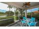 Screened-in lanai with seating, view of the community pond, and a ceiling fan, perfect for outdoor relaxation at 5630 Golf Pointe Dr # 108, Sarasota, FL 34243