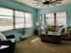 Comfortable living room with a cozy couch, rustic trunk coffee table, ceiling fan and bright turquoise walls at 5630 Golf Pointe Dr # 108, Sarasota, FL 34243