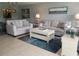 Airy living room boasts modern furnishings, tile floors, updated lighting, and soft color scheme at 5630 Golf Pointe Dr # 108, Sarasota, FL 34243