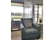 Living room featuring a comfortable chair, side table and view of outdoor scenery through large glass windows at 5630 Golf Pointe Dr # 108, Sarasota, FL 34243