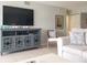 Bright living room featuring a large TV, decorative shelving unit and comfortable seating with stylish pillows at 5630 Golf Pointe Dr # 108, Sarasota, FL 34243