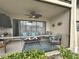 Relaxing screened patio area with cozy outdoor seating, ceiling fan, and tiled flooring at 5630 Golf Pointe Dr # 108, Sarasota, FL 34243