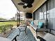 Screened patio offering a cozy seating area, ceiling fan, and serene outdoor view at 5630 Golf Pointe Dr # 108, Sarasota, FL 34243