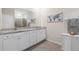 Bright bathroom features double vanity with granite counters and tiled shower at 5727 Oak Bridge Ct, Bradenton, FL 34211