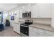 Kitchen featuring stainless steel appliances, granite countertops, and white cabinets at 5727 Oak Bridge Ct, Bradenton, FL 34211