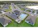 Aerial view of community pool with sundeck and parking surrounded by green lawns and neighborhood homes at 5727 Oak Bridge Ct, Bradenton, FL 34211