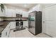 Bright kitchen boasts stainless steel refrigerator, granite counters and modern white cabinets at 633 Royal Empress Dr, Ruskin, FL 33570