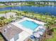 Relax at the community pool overlooking a serene lake, complete with lounge chairs and sun umbrellas at 633 Royal Empress Dr, Ruskin, FL 33570