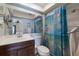 Cozy bathroom with wood vanity, soft blue walls, and shower with a blue patterned curtain at 6500 Flotilla Dr # 125, Holmes Beach, FL 34217