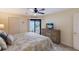Bedroom with a ceiling fan, comfortable decor, and sliding door access to a private waterfront balcony at 6500 Flotilla Dr # 125, Holmes Beach, FL 34217