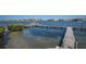 Picturesque waterfront scene with a private wooden dock extending into the calm bay, ideal for boating and water activities at 6500 Flotilla Dr # 125, Holmes Beach, FL 34217