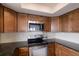Close up of updated kitchen with stainless steel appliances, tile backsplash and dark cabinets at 6500 Flotilla Dr # 125, Holmes Beach, FL 34217