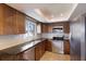 Updated kitchen featuring stainless steel appliances, granite countertops, tile flooring and dark wood cabinets at 6500 Flotilla Dr # 125, Holmes Beach, FL 34217