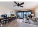 Living area with a ceiling fan, workspace area and sliding glass doors that lead to a waterfront balcony at 6500 Flotilla Dr # 125, Holmes Beach, FL 34217