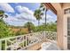 Balcony with white railings offering beautiful views of lush tropical foliage and terracotta rooftops at 7334 Regina Royale # 74, Sarasota, FL 34238