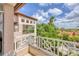 Balcony with white railings and beautiful views of palm trees and a building with terra cotta roof tiles at 7334 Regina Royale # 74, Sarasota, FL 34238